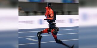 Red humanoid robot running on an indoor track at the 2026 World Humanoid Robot Games in Beijing