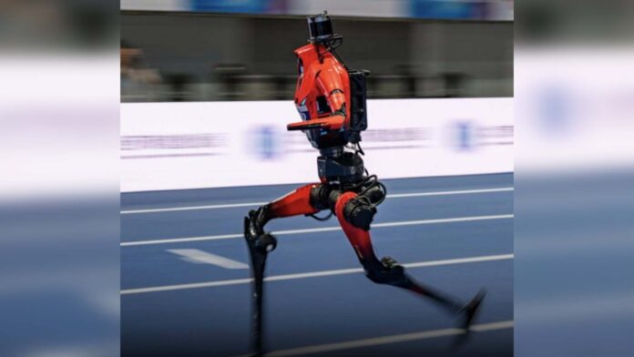 Red humanoid robot running on an indoor track at the 2026 World Humanoid Robot Games in Beijing