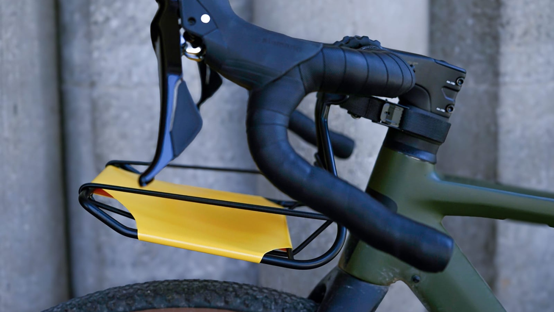 Side view of a yellow CargoMate rack installed on a green bicycle