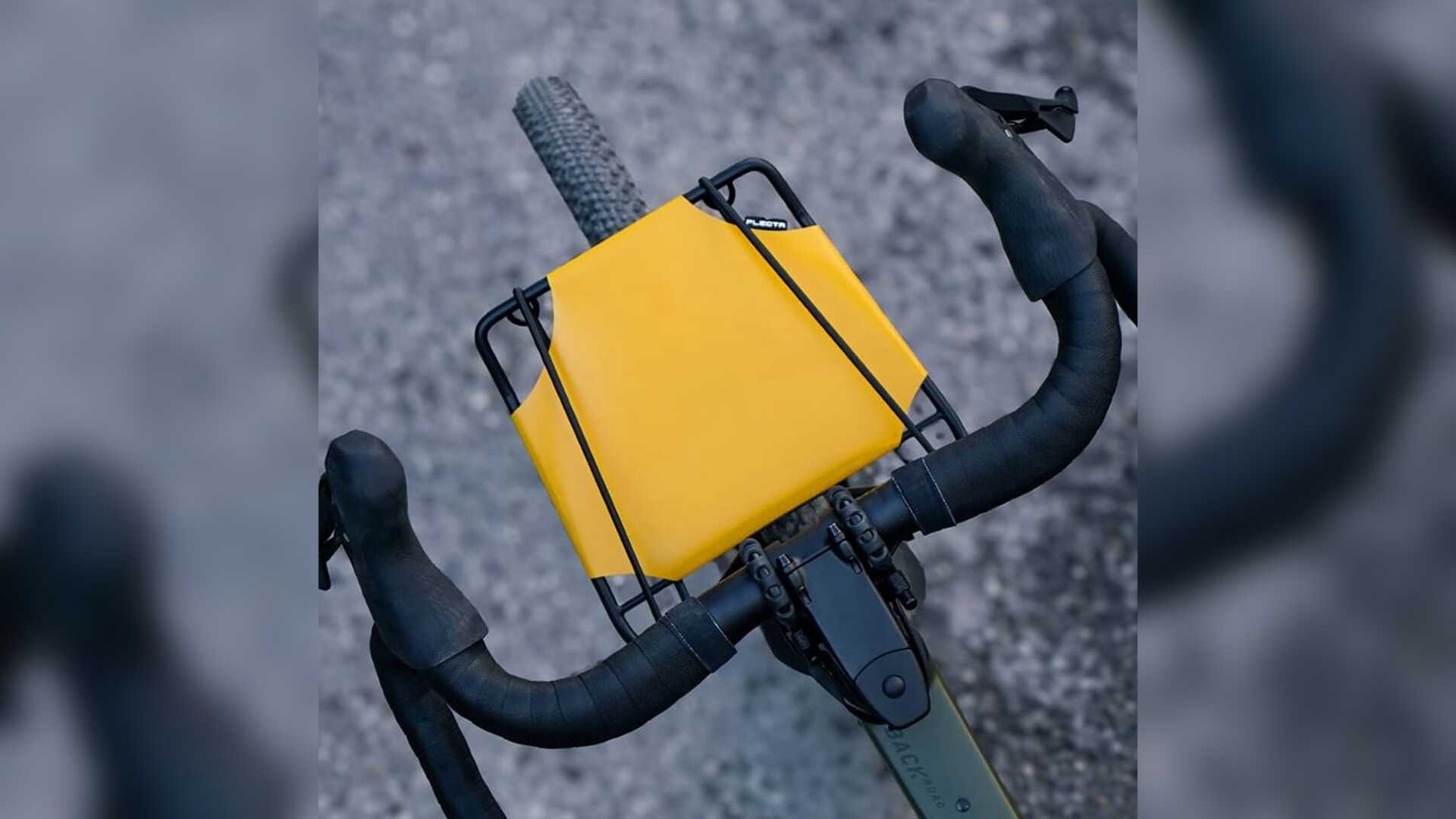 Top-down view of the yellow FLECTR CargoMate platform on a drop-handlebar bicycle