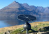 Iris T1 portable solar generator with its tracking panel facing the sun beside a mountain lake