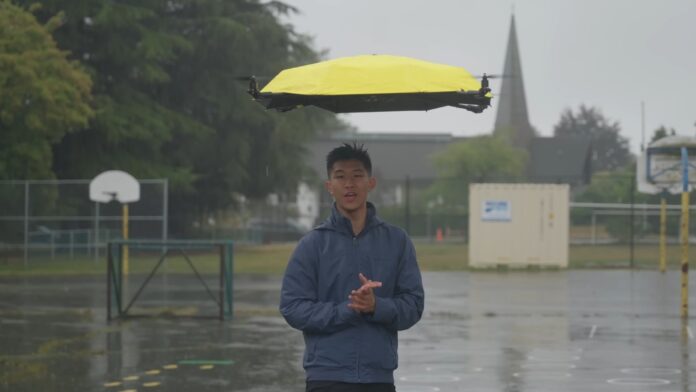 John Xu standing in heavy rain beneath his autonomous flying drone umbrella