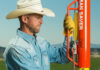 Man using a Rohrer Man Saver pneumatic post driver in a field
