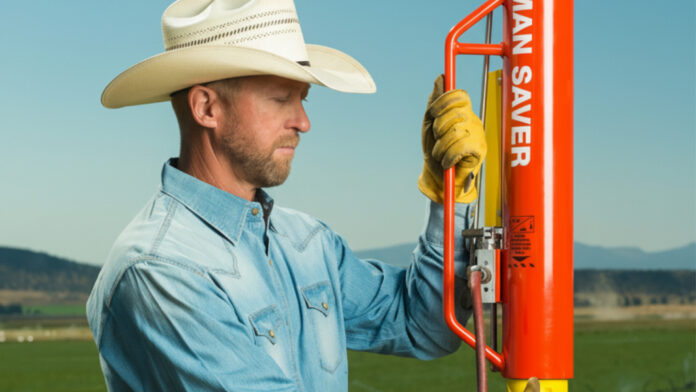 Man using a Rohrer Man Saver pneumatic post driver in a field