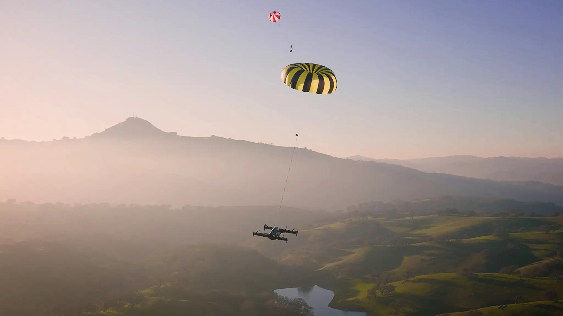 Pivotal Helix descending beneath its deployed emergency aircraft parachute