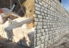 Redi-Rock concrete block installation beside a completed retaining wall