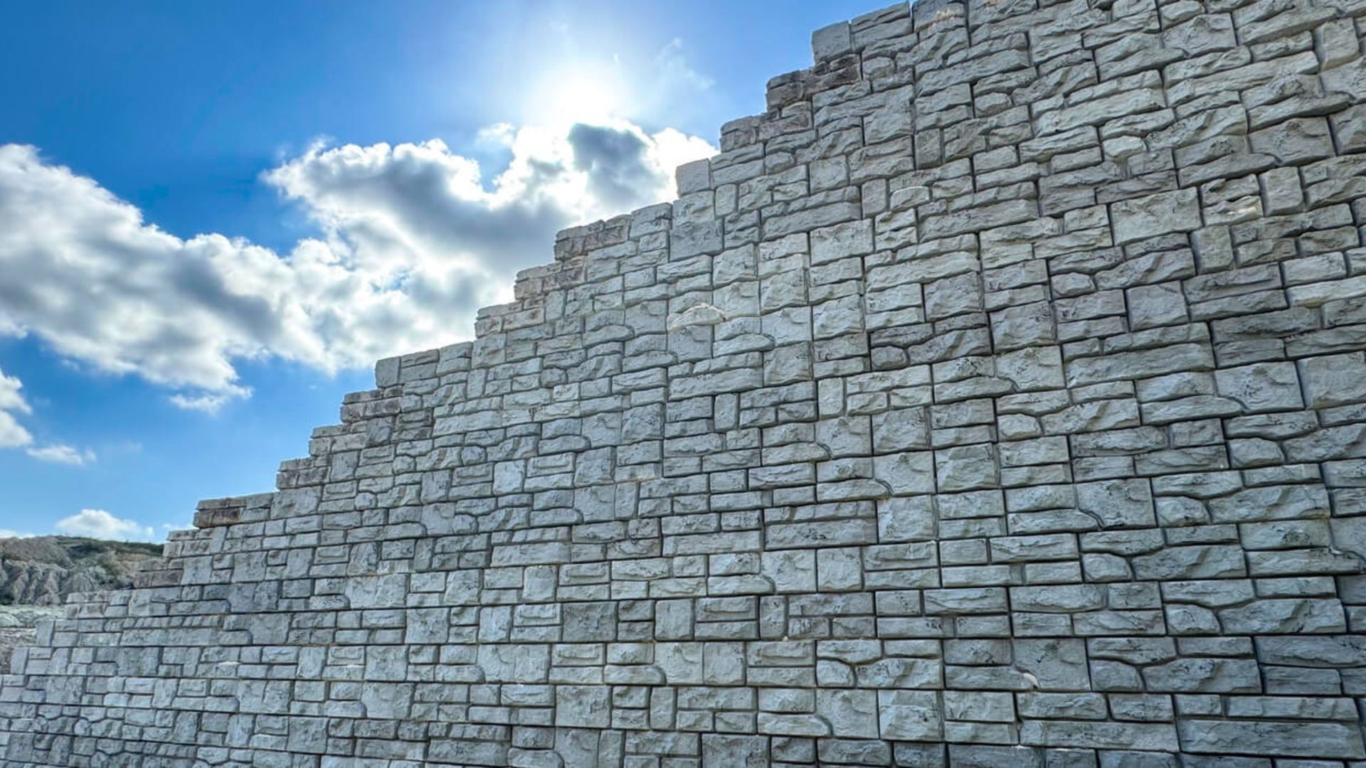 Tall Redi-Rock retaining wall with a natural stone-style concrete finish