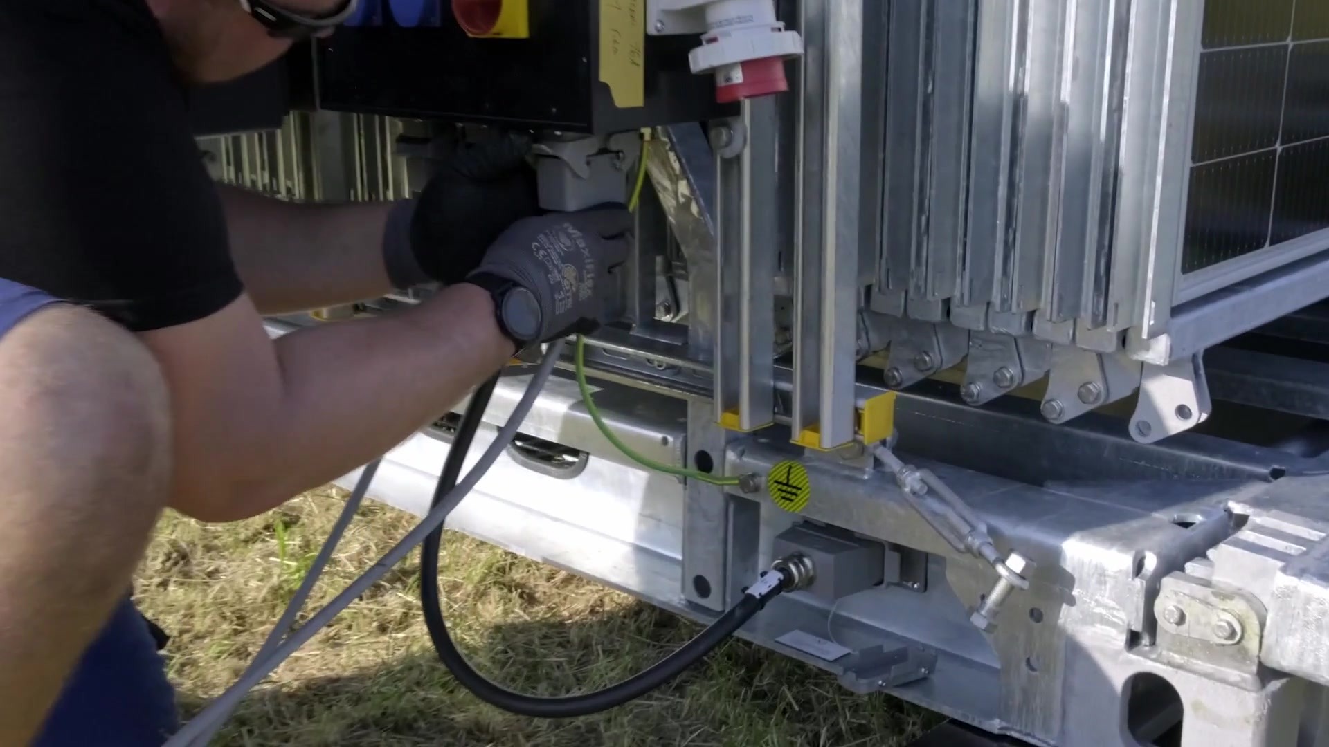 Technician connecting electrical components inside the Solarcontainer system