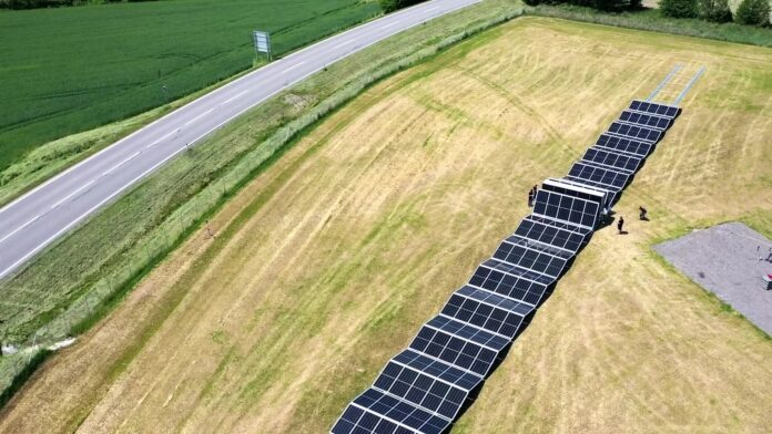 Aerial view of photovoltaic panels unfolding from the SolarCont Solarcontainer