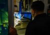 Sailor operating the HYBRiD-X metal 3D-printing and machining system aboard the USS Theodore Roosevelt