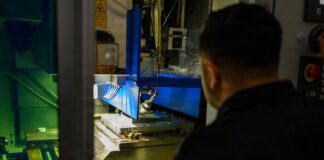 Sailor operating the HYBRiD-X metal 3D-printing and machining system aboard the USS Theodore Roosevelt