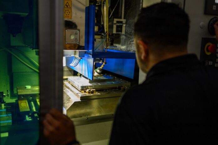 Sailor operating the HYBRiD-X metal 3D-printing and machining system aboard the USS Theodore Roosevelt