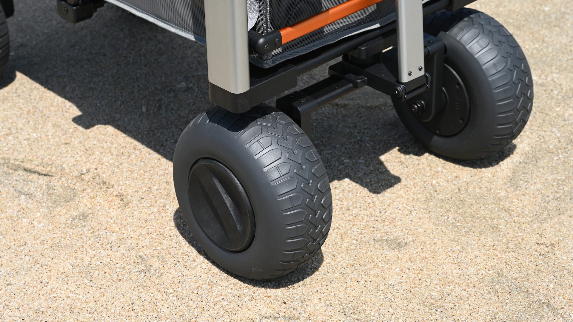 Close-up of the LITEFAR B1’s wide balloon tires rolling over beach sand