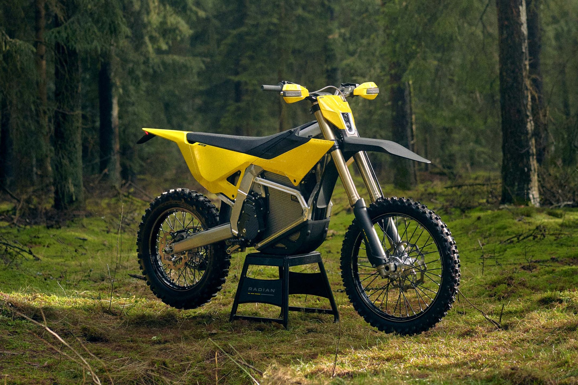 Yellow Radian EXR electric enduro motorcycle standing in a forest