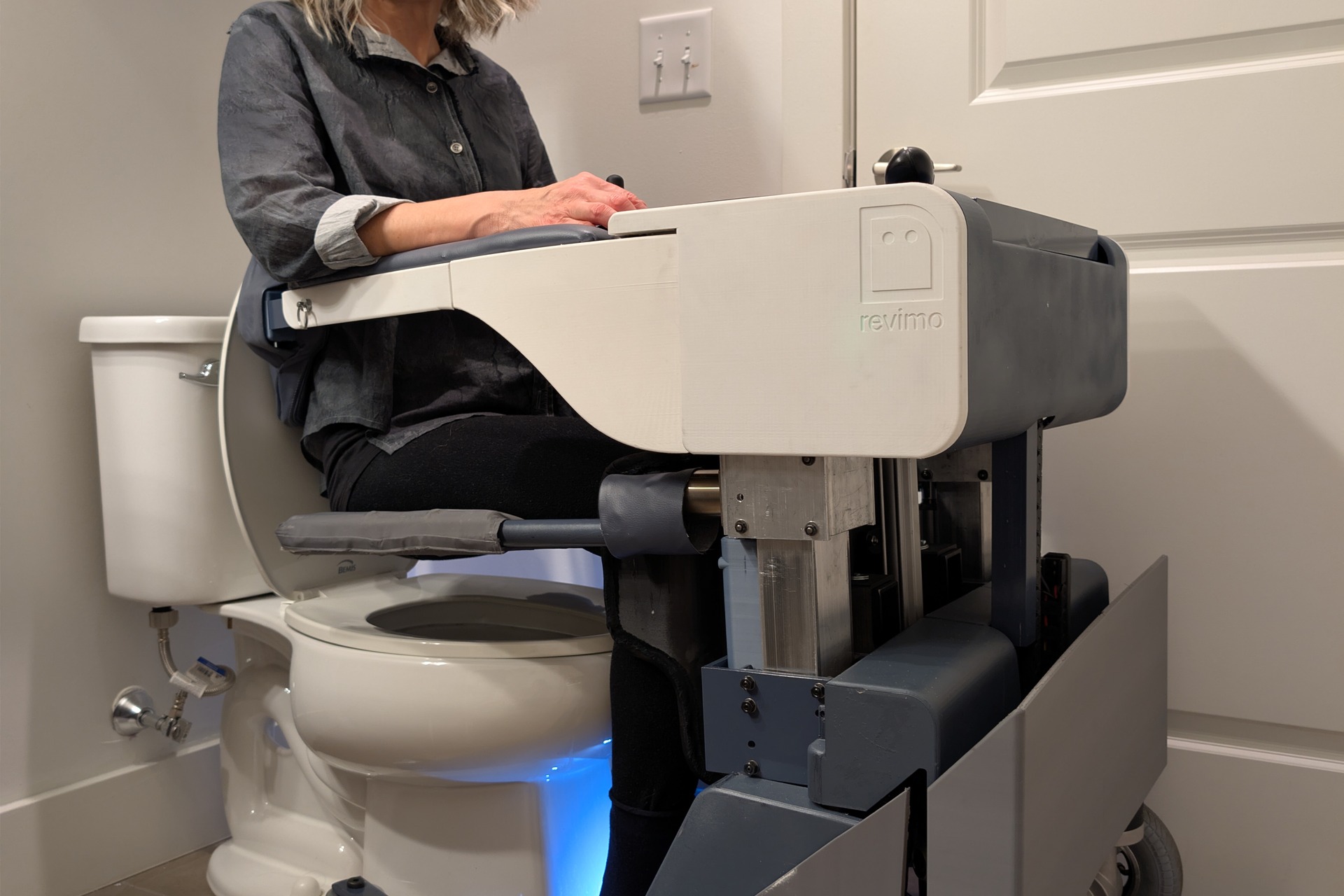 Woman using the REVIMO Niko positioned over a household toilet