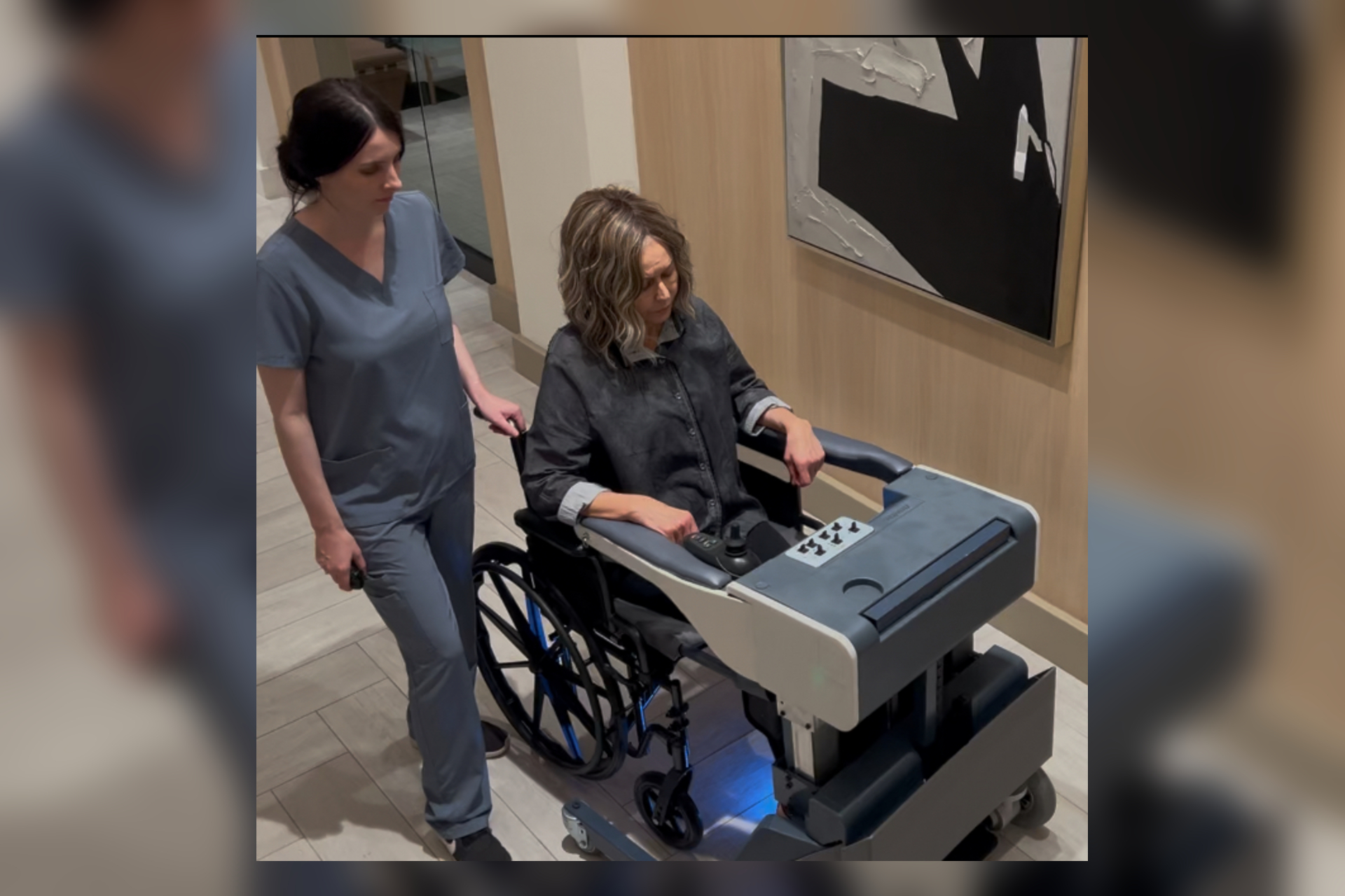 Wheelchair user positioned in the REVIMO Niko transfer device with a caregiver nearby