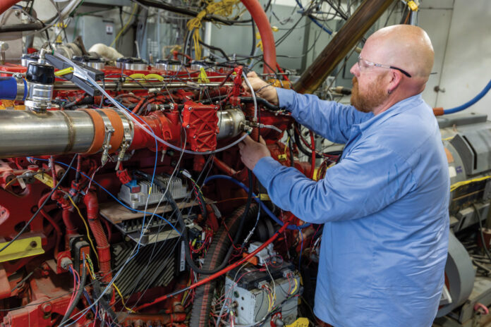 SwRI engineers working on a hydrogen-powered heavy-duty truck engine in a test cell