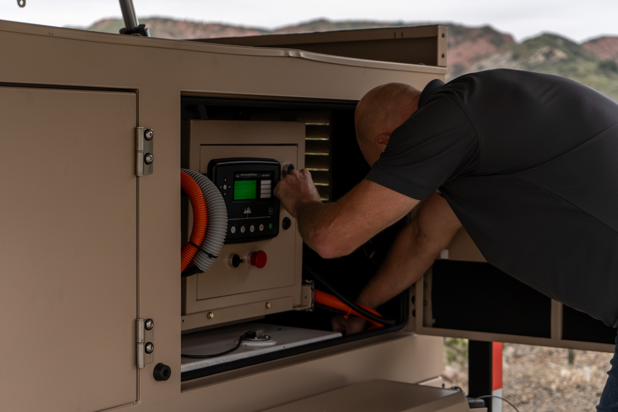 Operator using the electronic control panel inside a 123eSolar STG-4 equipment compartment