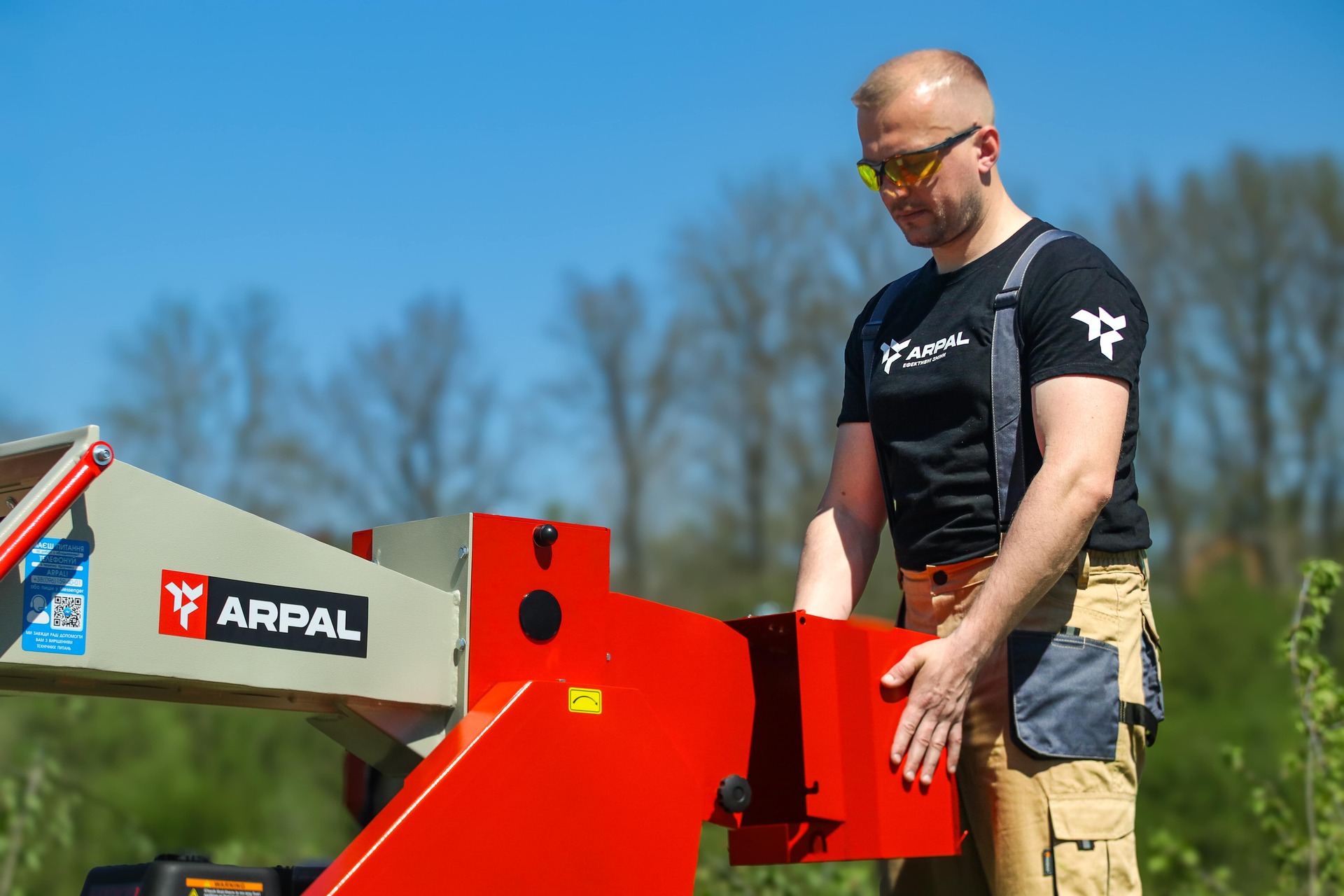 Operator standing at the long feed hopper of the ARPAL AM-80BD wood chipper