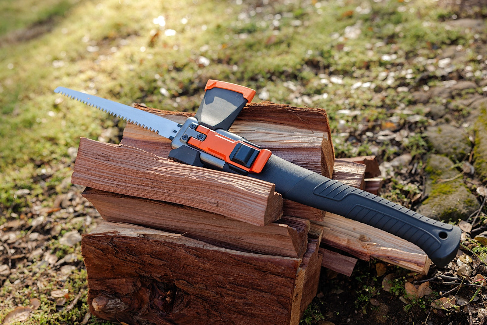 Adventure Mate AM-V3 multitool with saw blade extended on stacked firewood