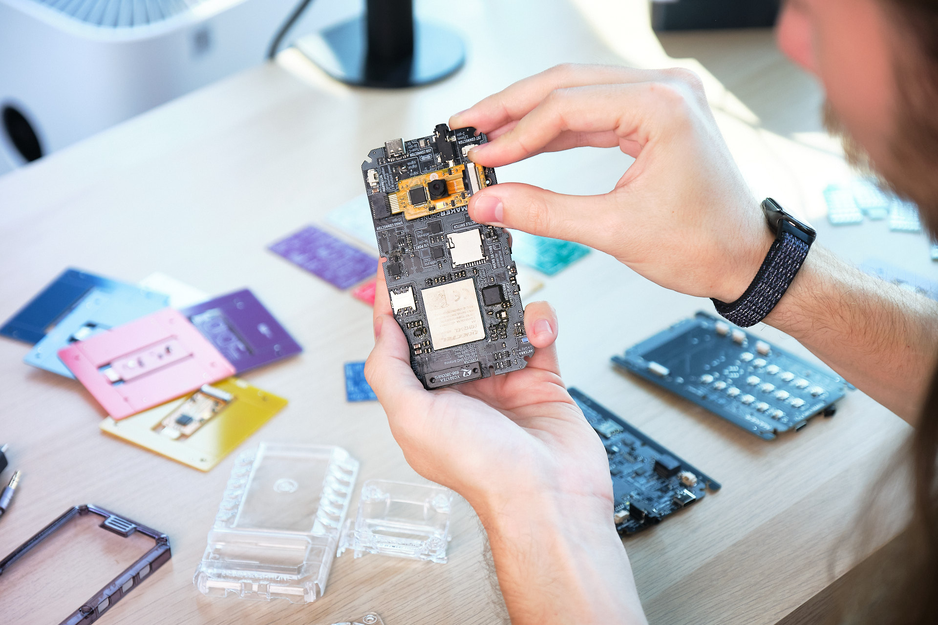 Developer fitting a component into the back of a MAKERphone 2.0
