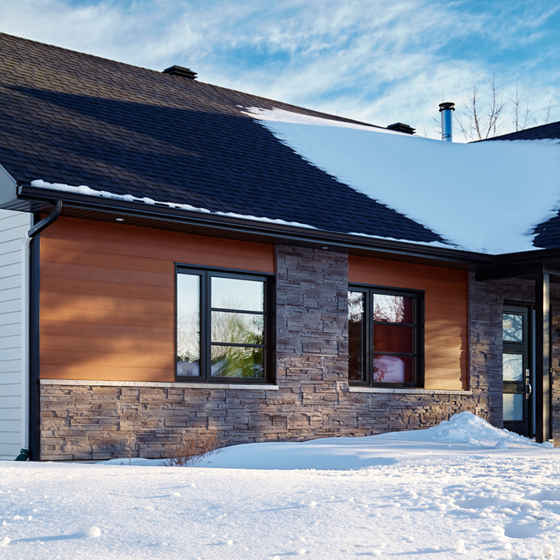 Snow-covered house featuring Be.On Stone Element veneer on its exterior walls