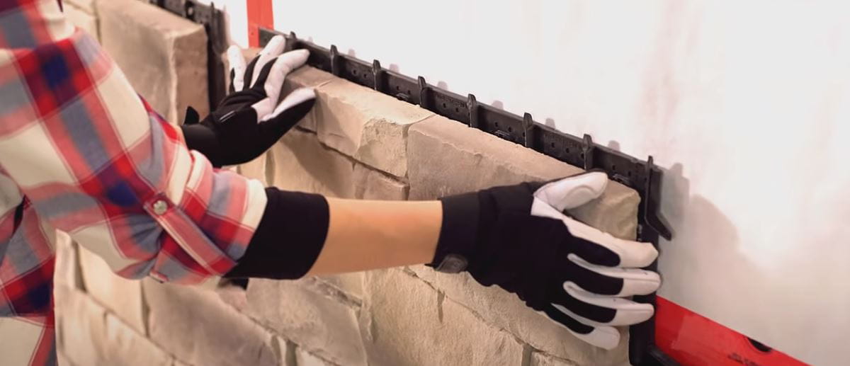 Installer positioning a Be.On Stone panel over concealed mounting channels