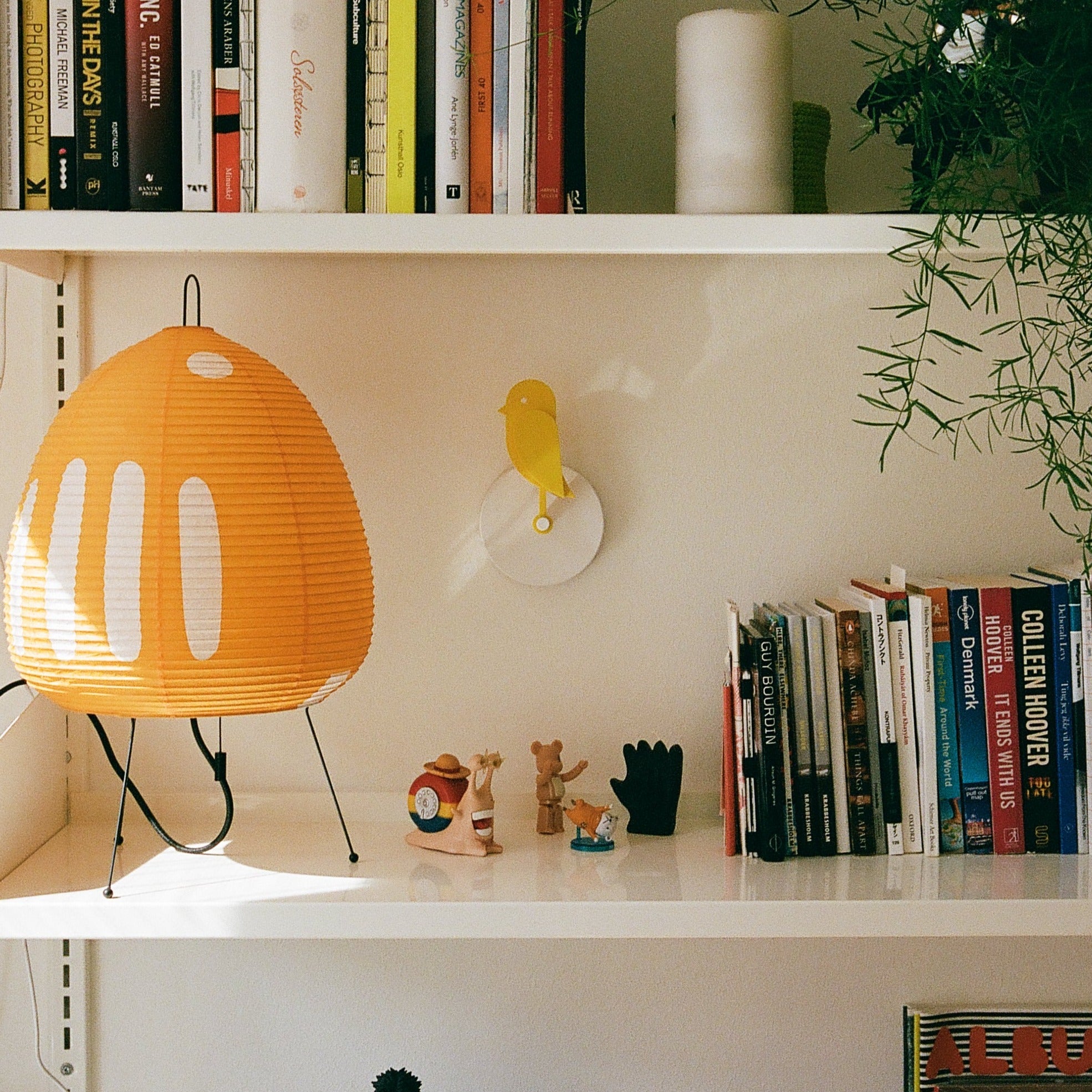 Yellow Birdie 2.0 CO2 monitor mounted beside a bookshelf