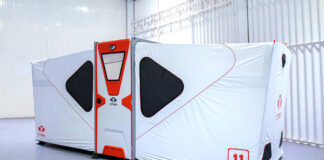 Fully deployed white and orange CMAX CX20 foldable shelter with raised floor and adjustable supporting feet