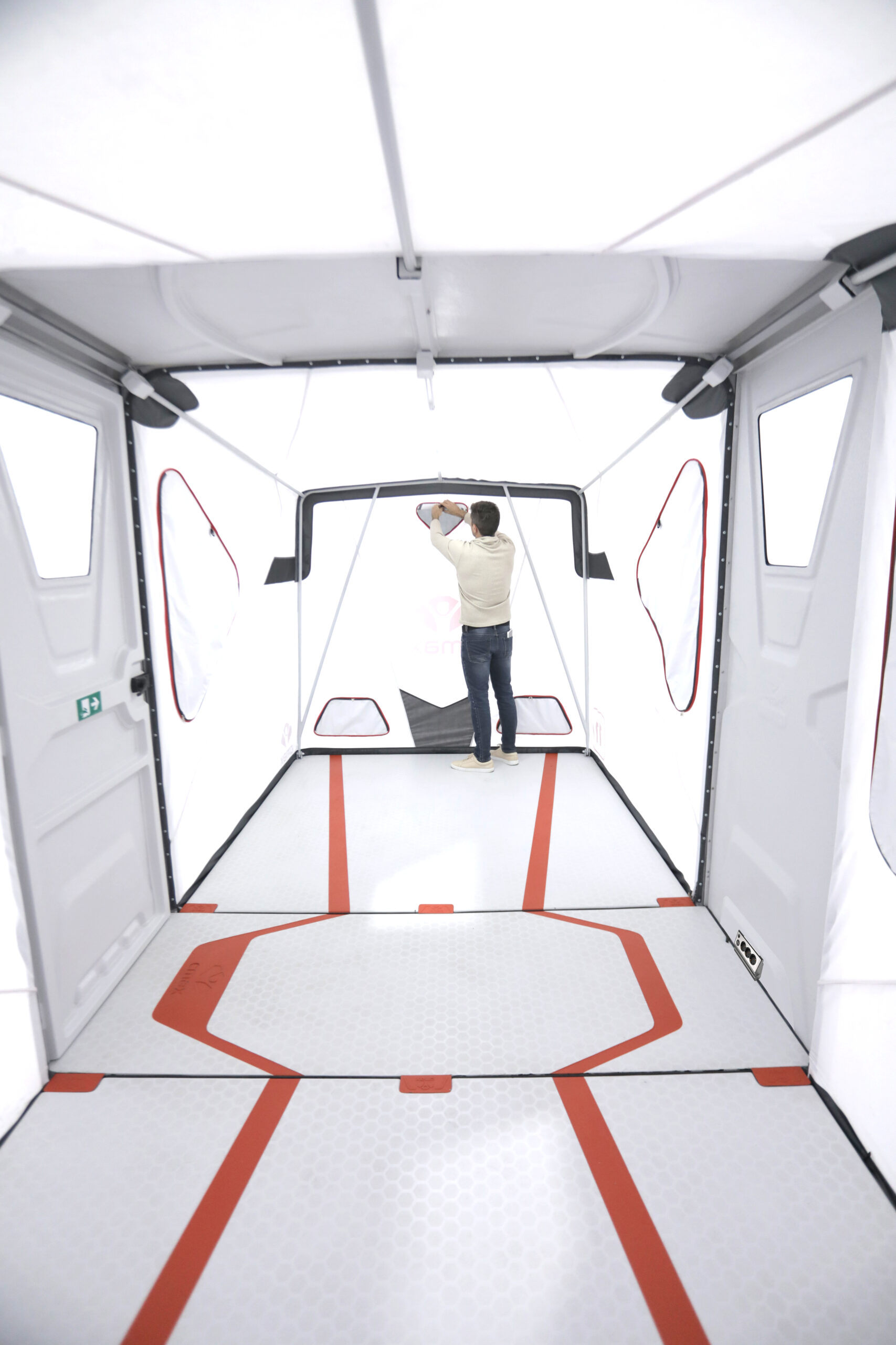 Interior view through a deployed CMAX shelter showing its rigid floor, fabric walls and high ceiling