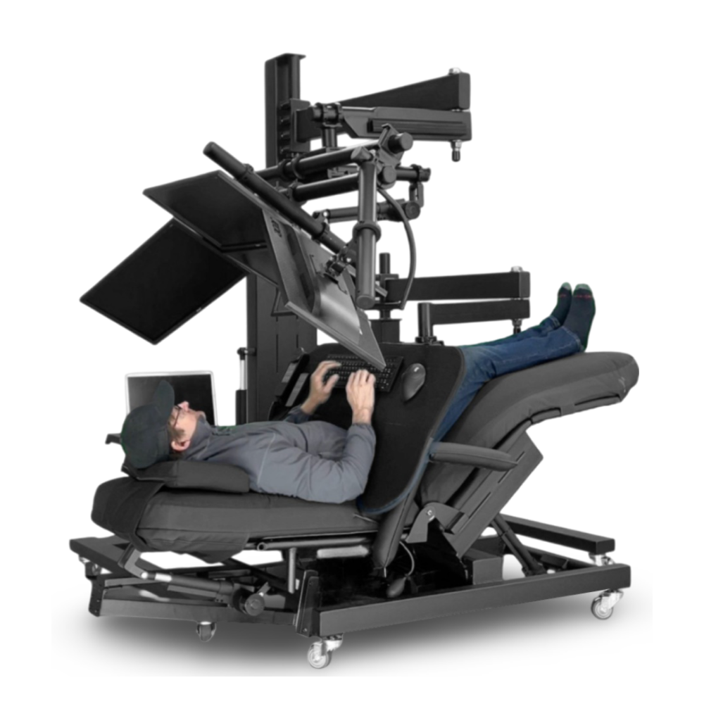 User lying nearly flat while working with tilted monitors and keyboard tray