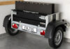 Faltos cargo trailer folded upright beside a car inside a garage