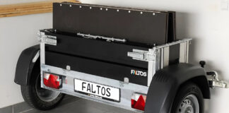 Faltos cargo trailer folded upright beside a car inside a garage