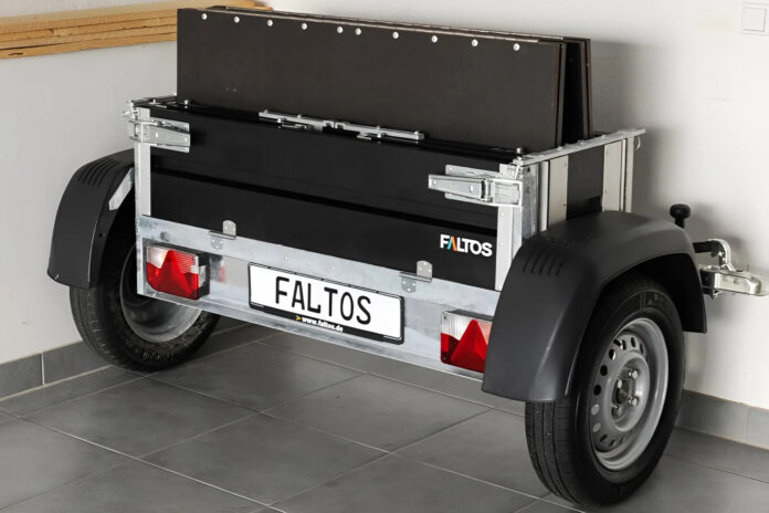 Faltos cargo trailer folded upright beside a car inside a garage