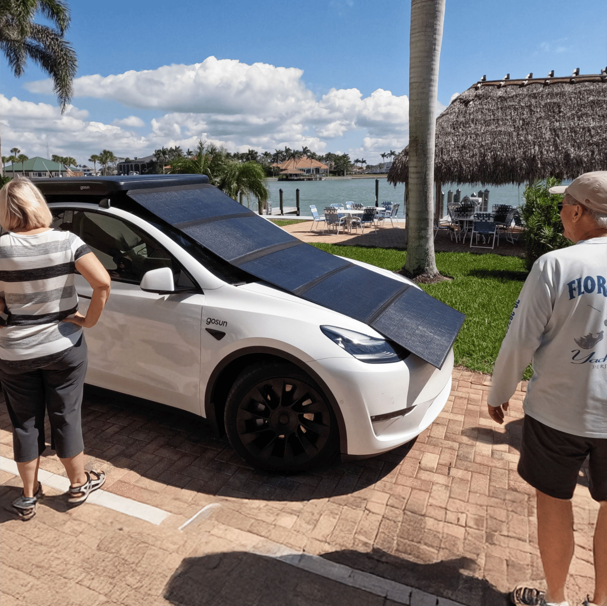 GoSun EV Solar Charger panels unfolded over a parked white electric car