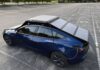Blue electric car parked beneath the fully deployed GoSun EV Solar Charger panels.