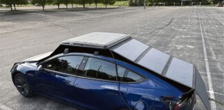Blue electric car parked beneath the fully deployed GoSun EV Solar Charger panels.