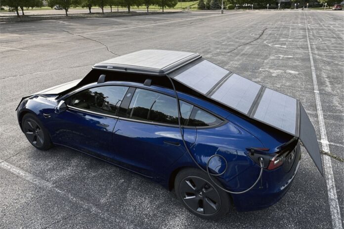 Blue electric car parked beneath the fully deployed GoSun EV Solar Charger panels.