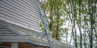 Extension ladder fitted with two ProtecMi stabilizer arms resting on a shingle roof