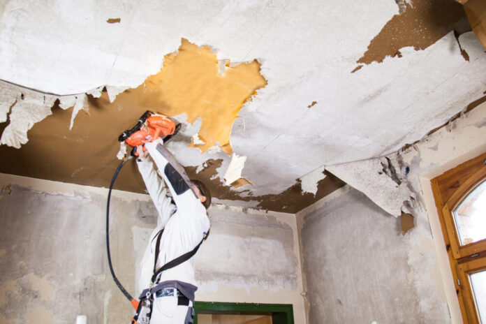 Worker using a ROKAMAT Chameleon to remove wallpaper from a ceiling
