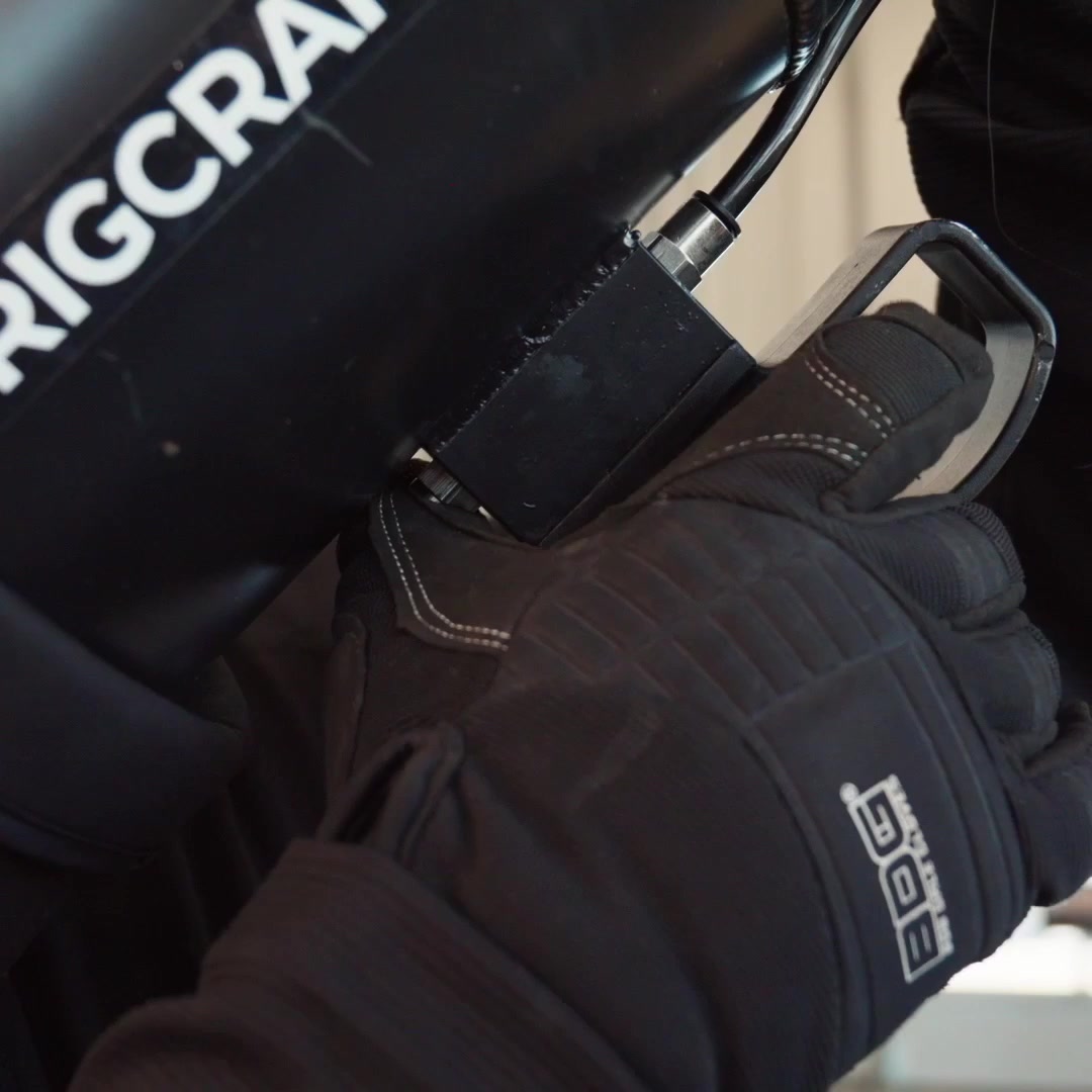 Gloved hand operating the safety control on the RigCraftor Pneumatic Strap Launcher
