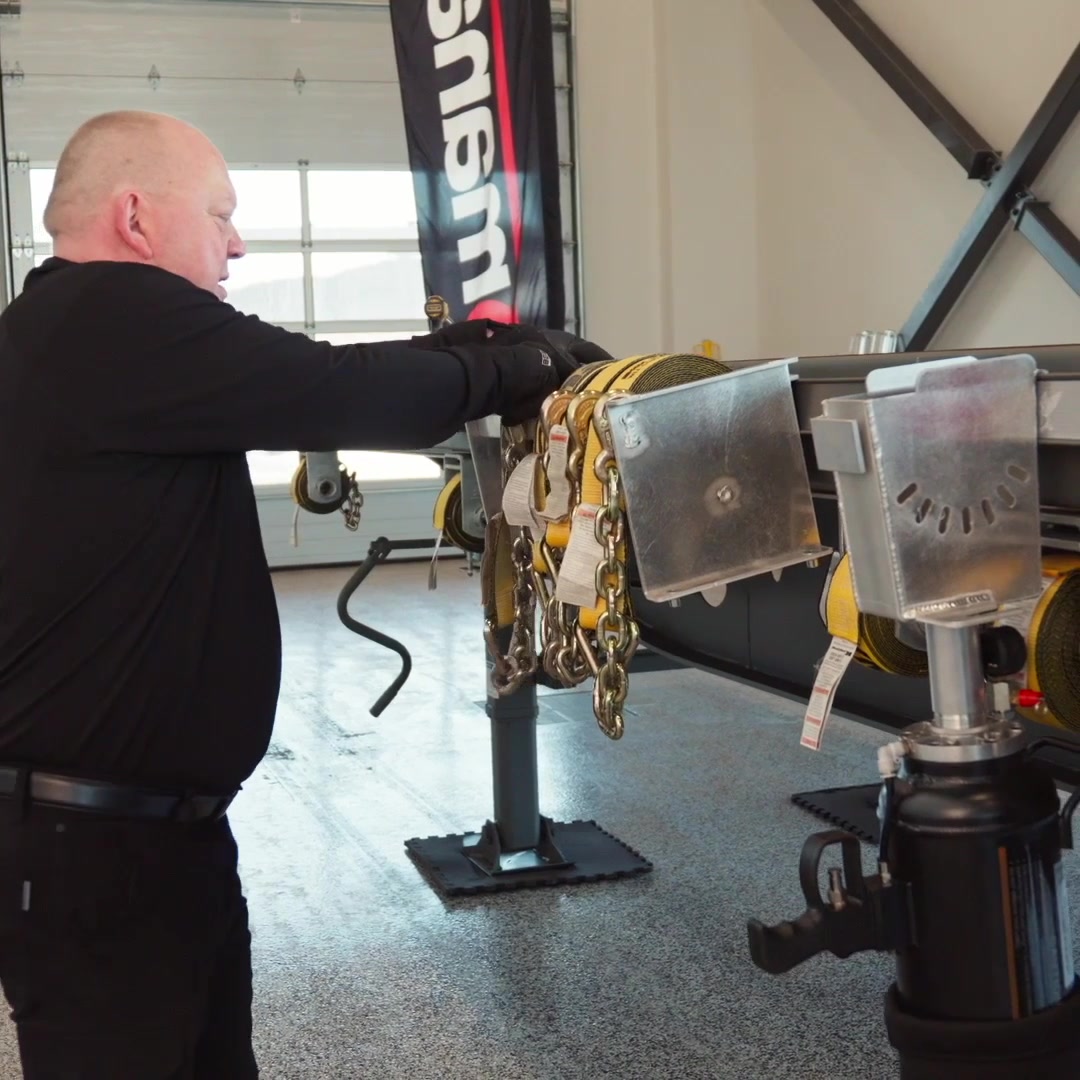 Operator placing a rolled tie-down strap into the RigCraftor launcher's holder