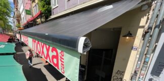 Retractable SolarMarkise photovoltaic awnings shading outdoor restaurant seating in Cologne