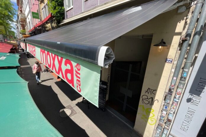 Retractable SolarMarkise photovoltaic awnings shading outdoor restaurant seating in Cologne