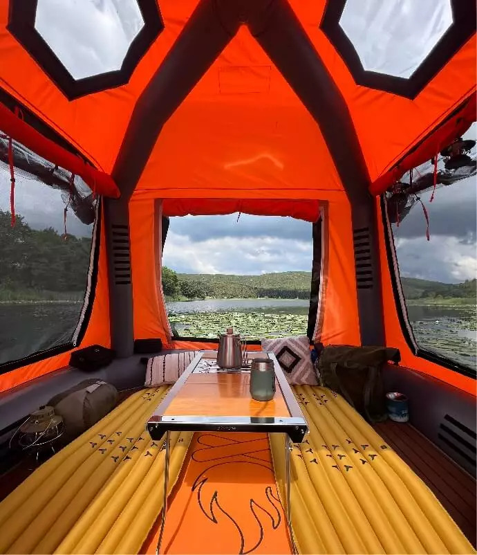 View through the screened doorway into the Sönmez Floating Tent’s orange interior