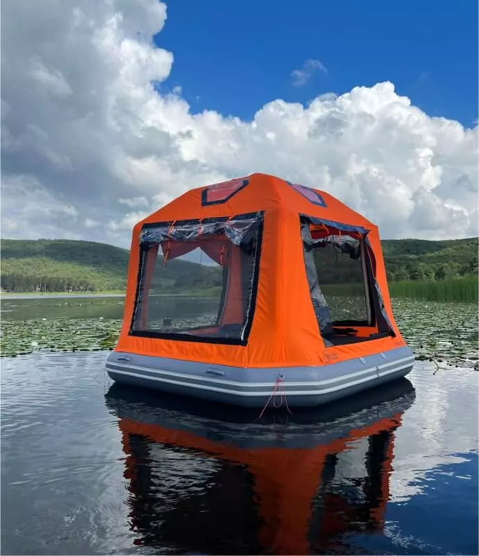 Orange Sönmez Floating Tent positioned on a calm lake near the shoreline