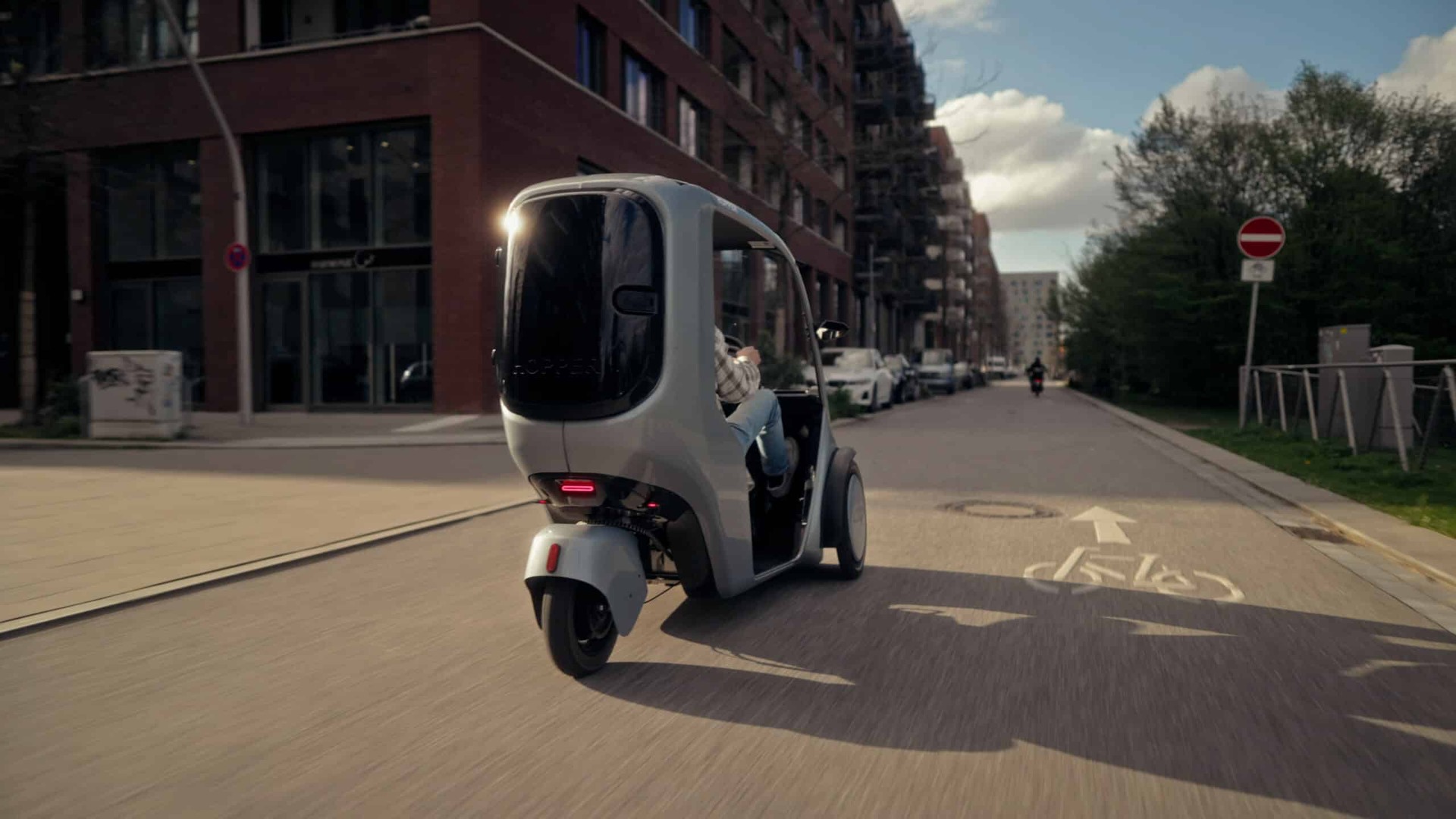 Rear view of a HOPPER electric cargo bike traveling along an urban bicycle street
