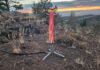 Happy Caveman propane campfire glowing red on rocky ground at sunset