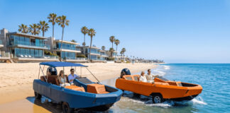 Blue and orange WaterCar EV amphibious vehicles driving out of shallow ocean water onto a beach