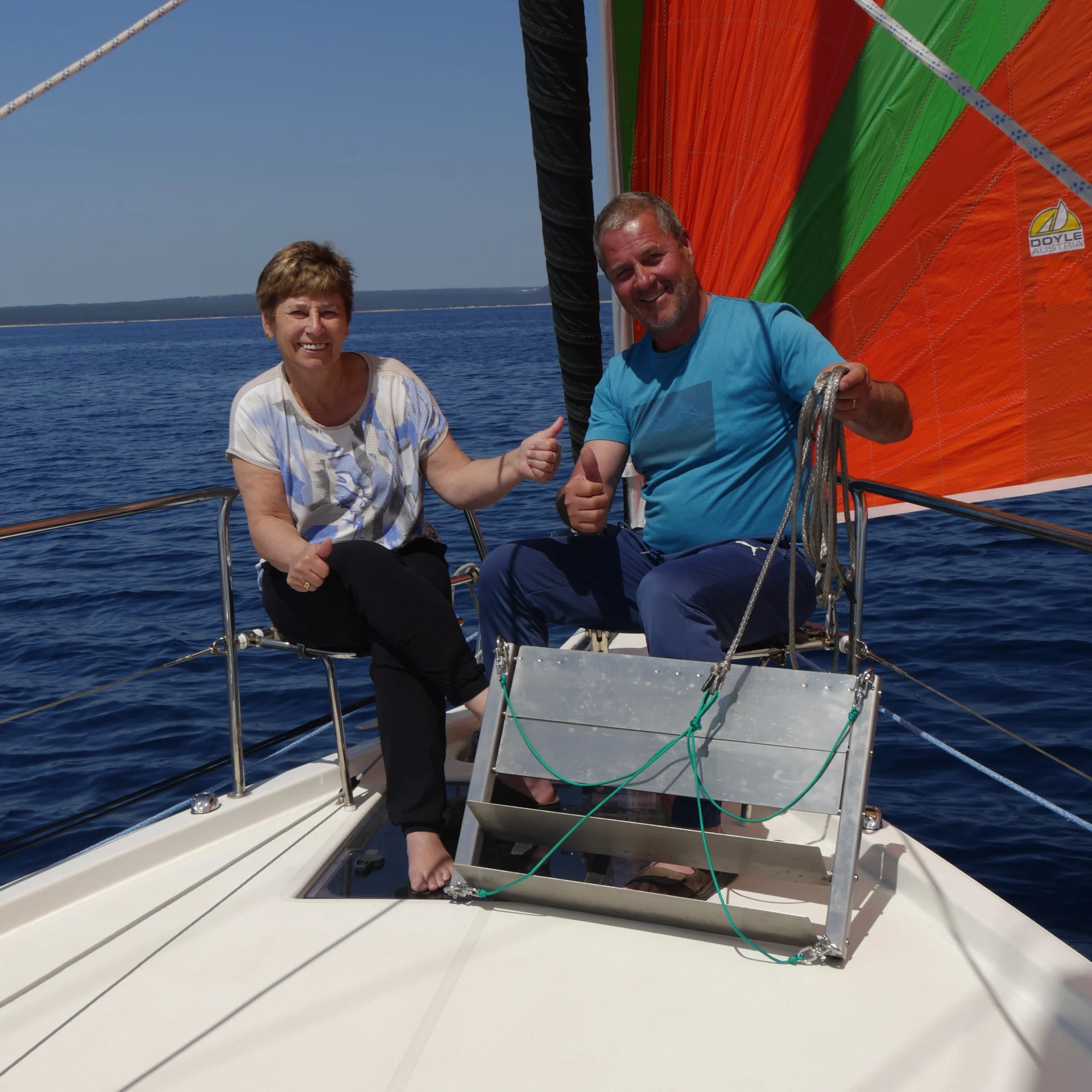 Wobbelstopper founders Anita and Herbert holding the boat stabilizer aboard a sailboat